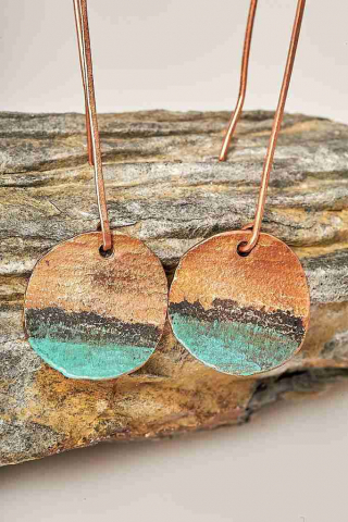 Copper earrings with green patina on the natural rock